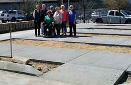 A group of individuals pose on the new concrete walkways.
