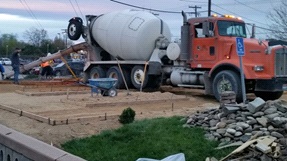A truck pours concrete for garden walkways.